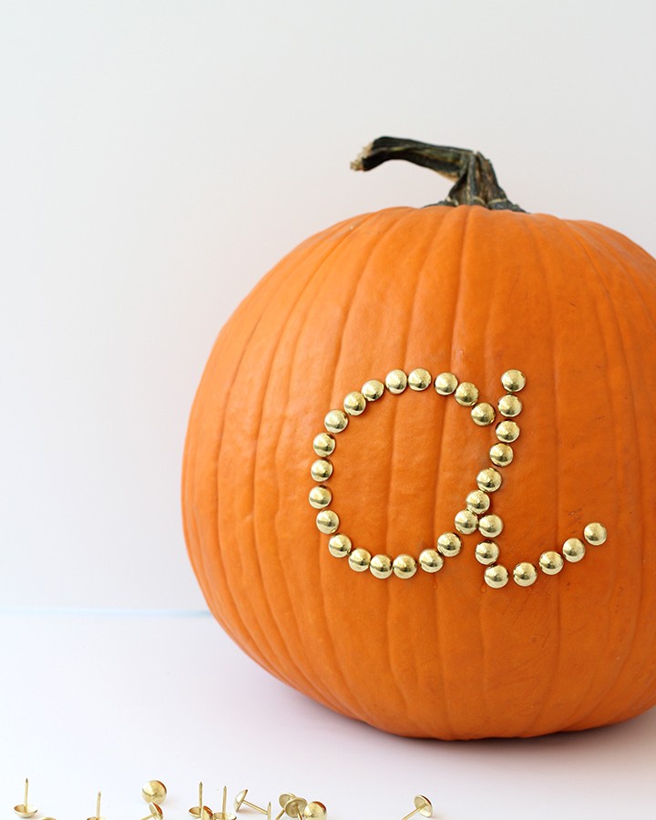 Use gold upholstery tacks to make this simple initial pumpkin this Halloween.