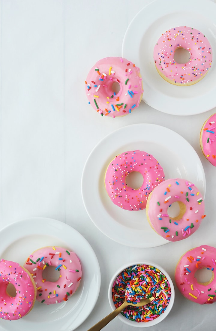 Baked Vanilla Donuts topped with pink frosting and sprinkles!